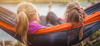 beeld van achterhoofd van twee tienermeisjes in een hangmat