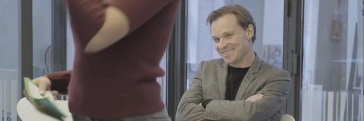 Bruno Vanobbergen die glimlacht naar de jonge dame die hem gaat interviewen