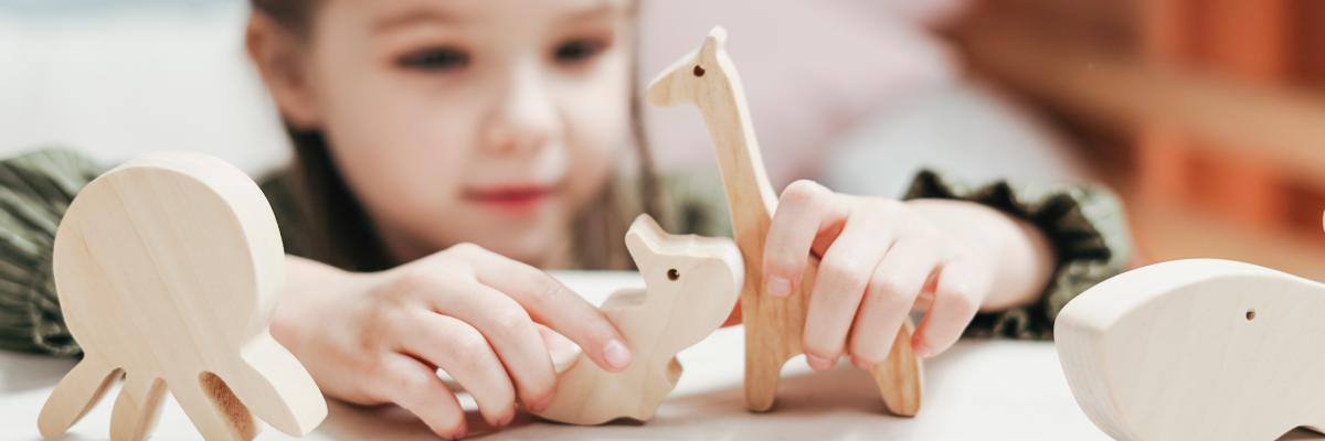 Meisje dat speel met houten speelgoed