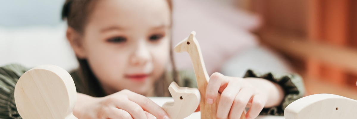 Meisje speelt met houten speelgoeddieren
