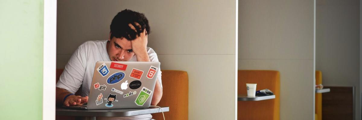 Jonge man, werkend op zijn laptop