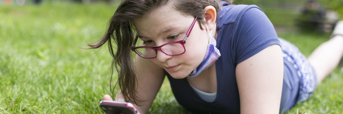 meisje in gras met smartphone