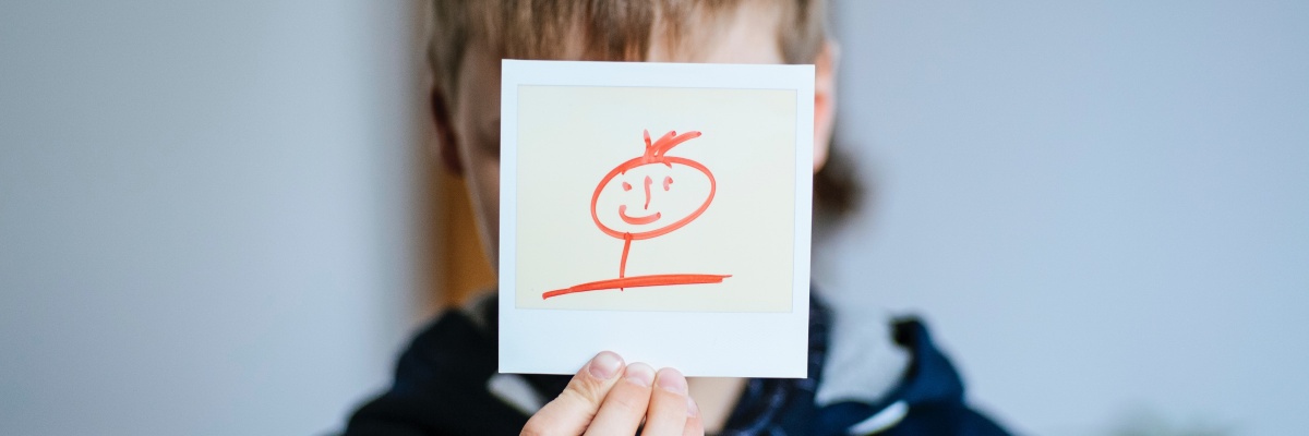 Jongen met een smiley voor zijn gezicht