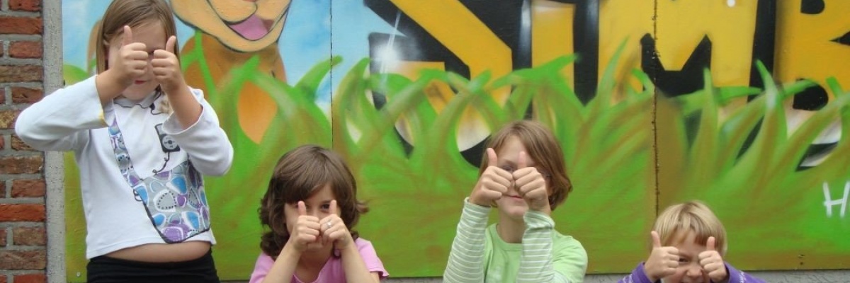4 kinderen met omhoog gestoken duim voor het simbahuis.