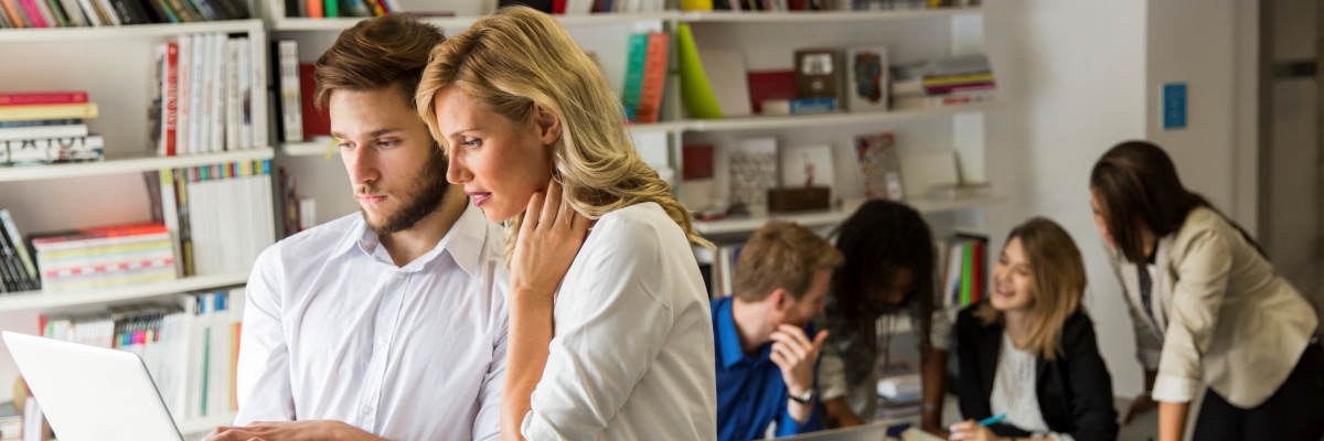 collega's die samenwerken, koppel dat samen kijkt op laptop