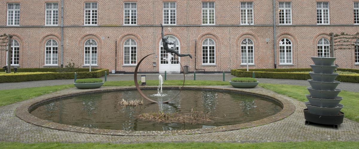 De ingang van campus Ruiselede, een waterpartij met een standbeeld voor de ingang.