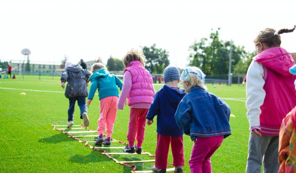 Kinderen op een rij een spel met treden aan het spelen.