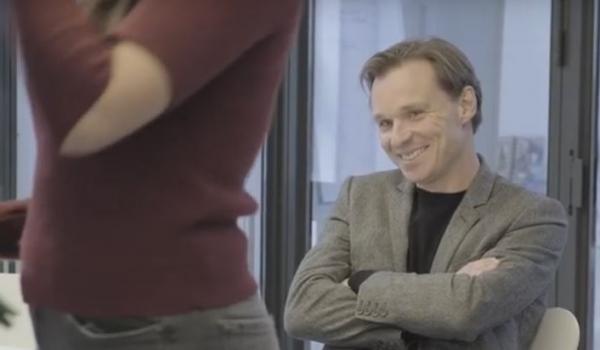 Bruno Vanobbergen die glimlacht naar de jonge dame die hem gaat interviewen