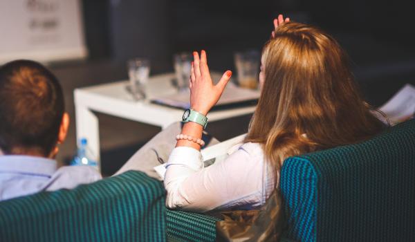 Vrouw langs achteren die duidelijk een uitleg met handgebaren maakt