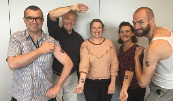 Stefaan Van Mulders en enkele werknemers van toenmalig agentschap Jongerenwelzijn met een opplak tattoo
