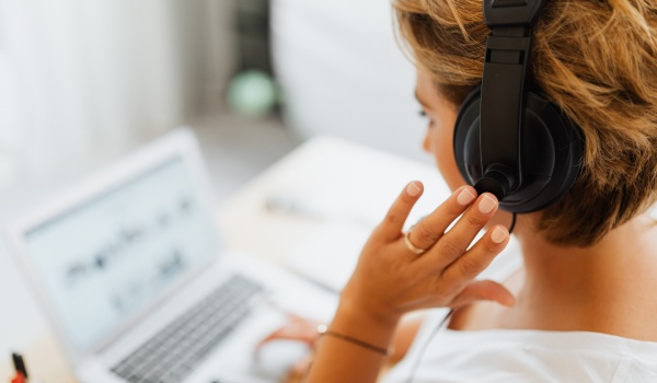 vrouw met headset aan laptop