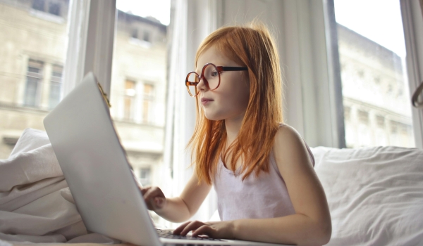 jong meisje zittend aan laptop