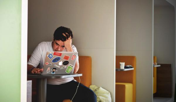 Jonge man, werkend op zijn laptop
