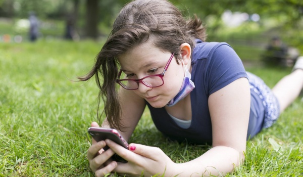 meisje in gras met smartphone