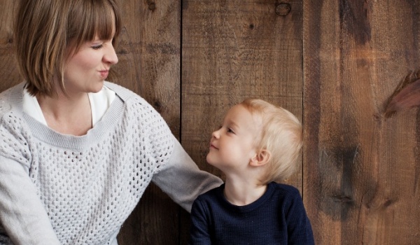 vrouw met kindje trekken gekke snoet naar elkaar