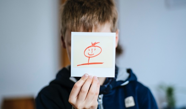 Jongen met een smiley voor zijn gezicht