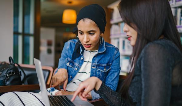 Jonge vrouwen, werkend op dezelfde computer