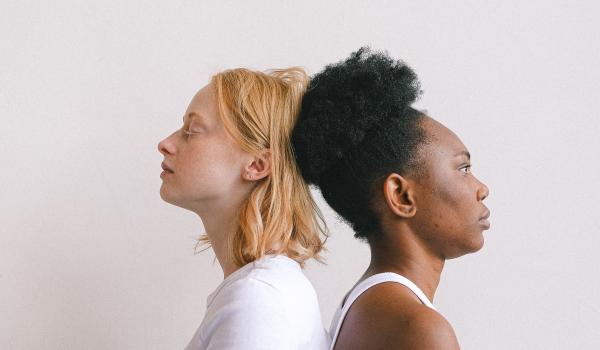 Twee vrouwen zittend met de rug tegen elkaar.