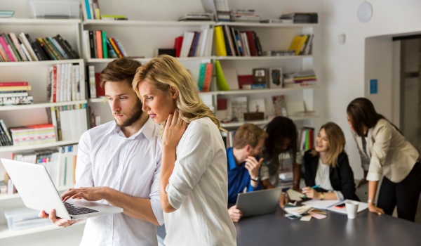 collega's die samenwerken, koppel dat samen kijkt op laptop