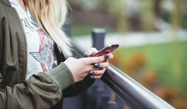 Een jonge vrouw met haar gsm in haar handen