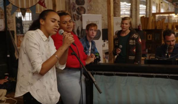 Jonge vrouw die met veel passie zingt, begeleid door de Troubadours op piano