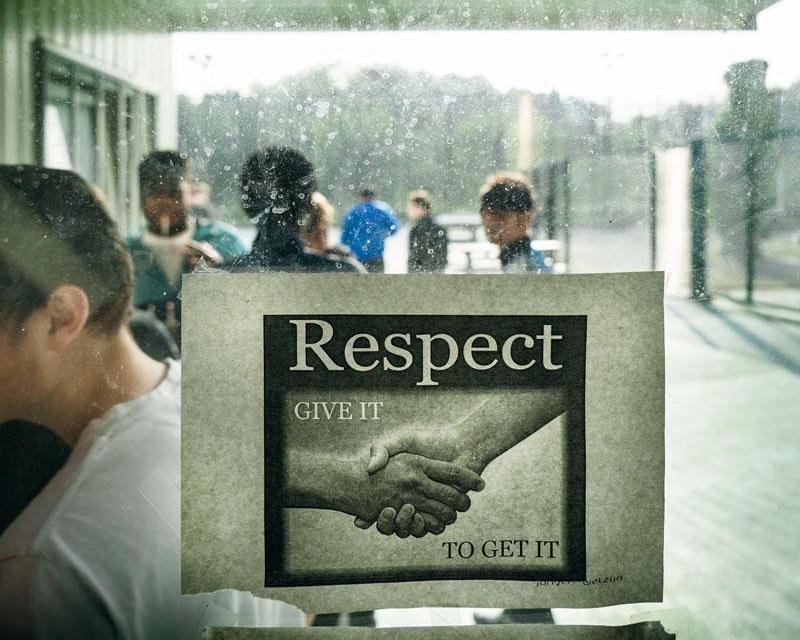 De jongeren van de gemeenschapsinstelling gaan naar binnen, op het raam plakt een affiche over respect