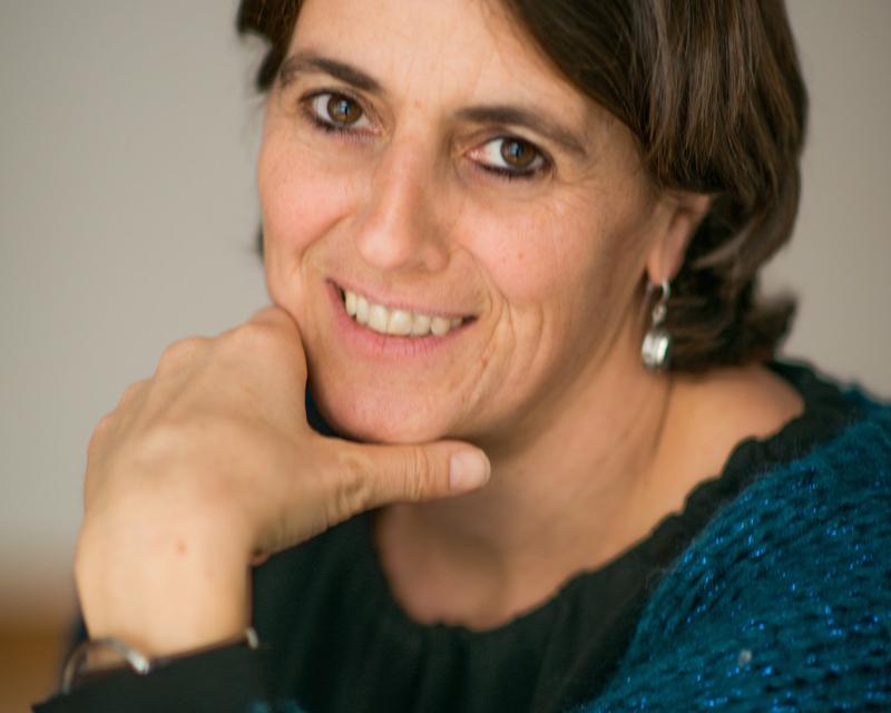 Katrien Verhegge, met brede glimlach en donkerblauwe trui