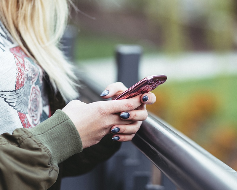 Een jonge vrouw met haar gsm in haar handen