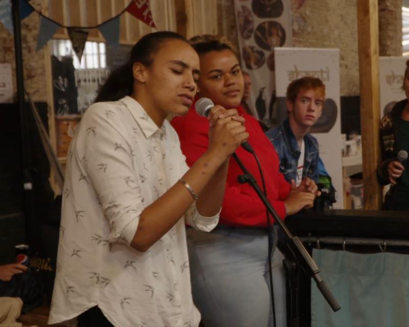 Jonge vrouw die met veel passie zingt, begeleid door de Troubadours op piano