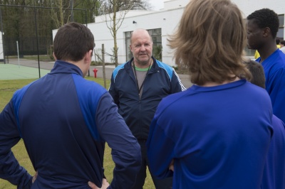 Een turnleerkracht die voetballes geeft