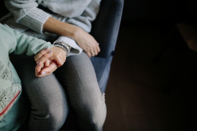 Hand van een moeder die het handje van haar kind neemt