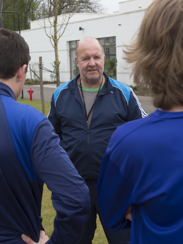 Een turnleerkracht die voetballes geeft