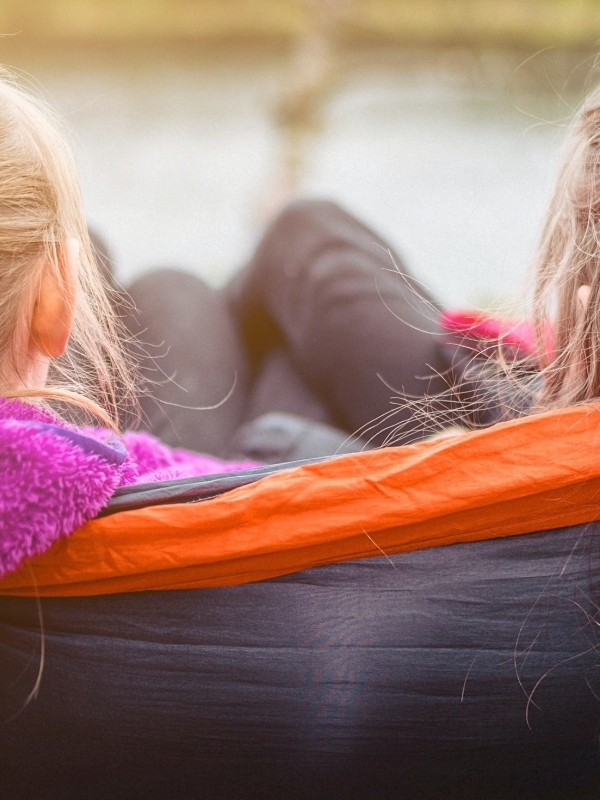 beeld van achterhoofd van twee tienermeisjes in een hangmat